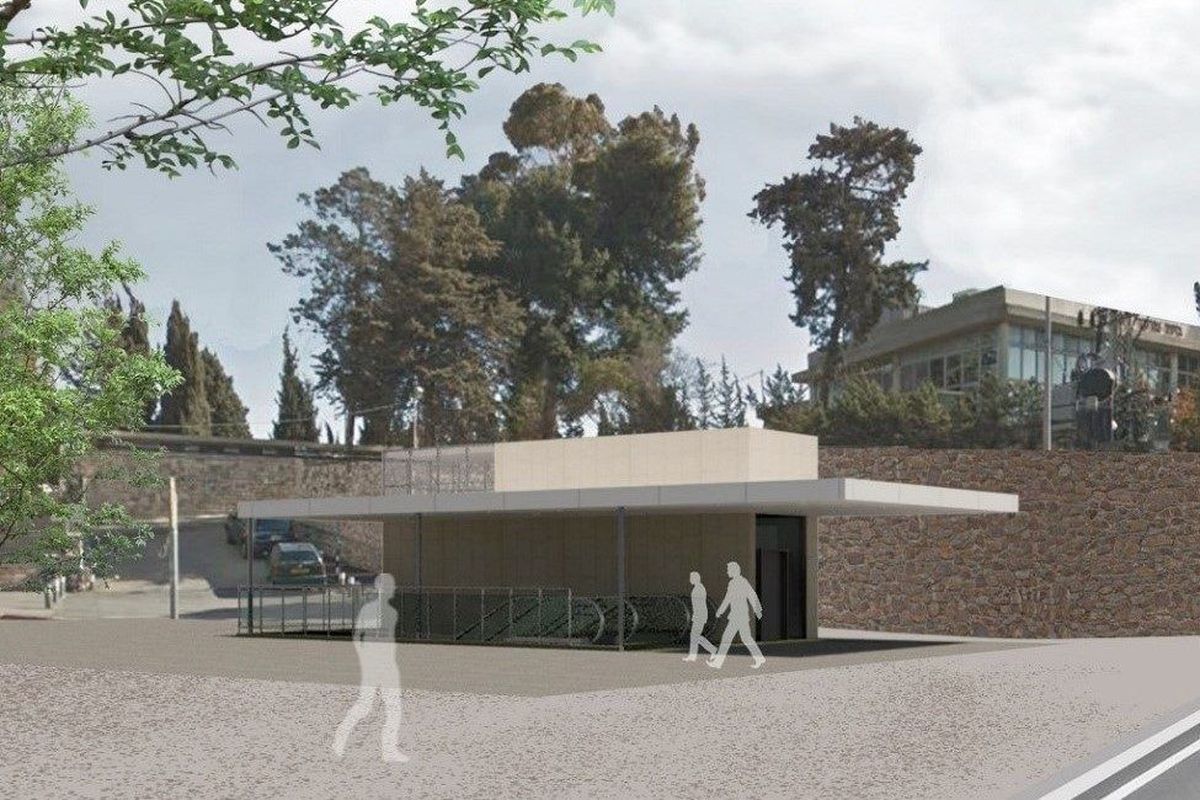 Ein moderner Bau mit einem begrünten Bereich, umgeben von Bäumen und einer befahrenen Straße im Hintergrund.