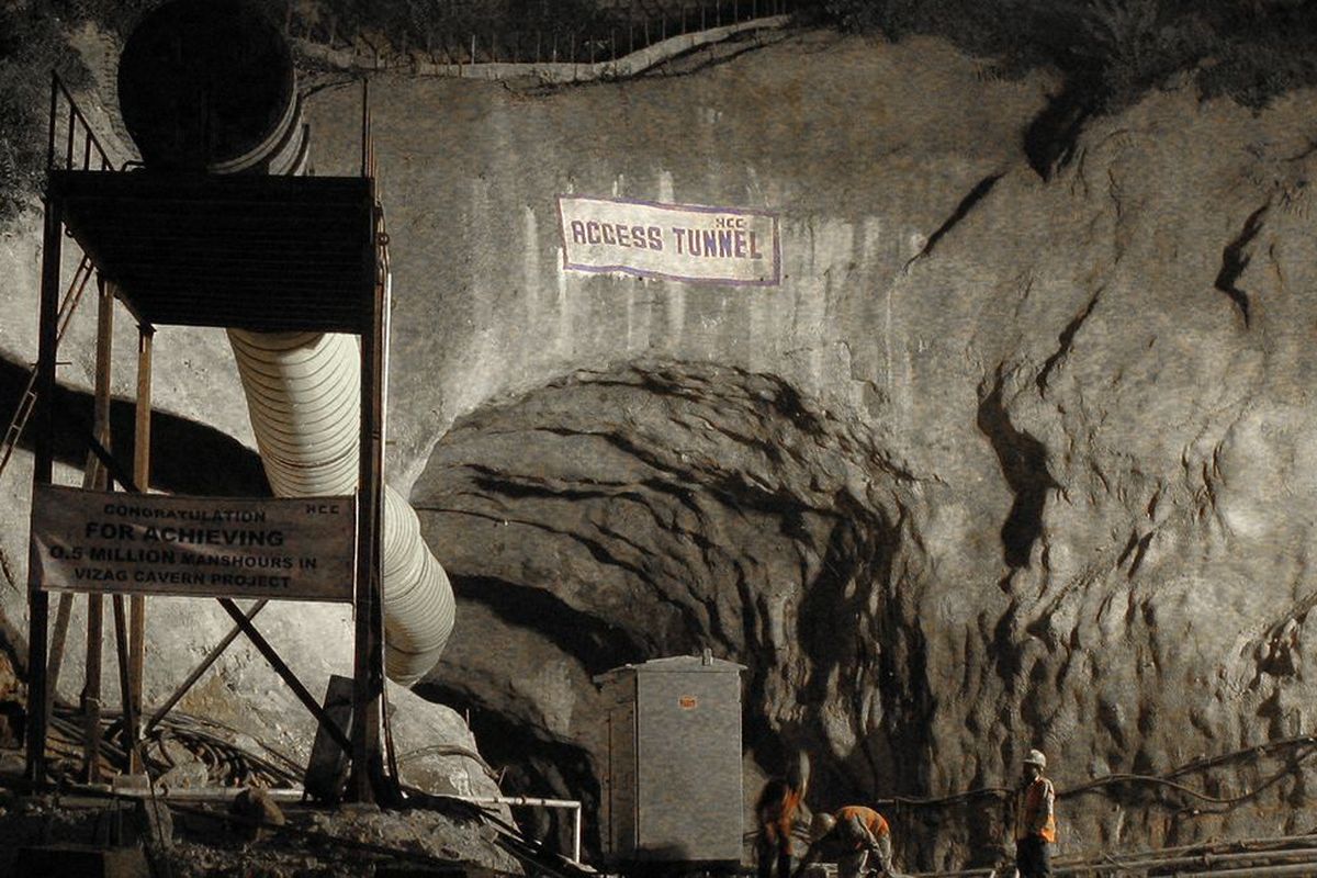 Ein Tunnelportal mit einem Schild „Access Tunnel“ und Bauarbeiten im Inneren, beleuchtet von schwachem Licht.